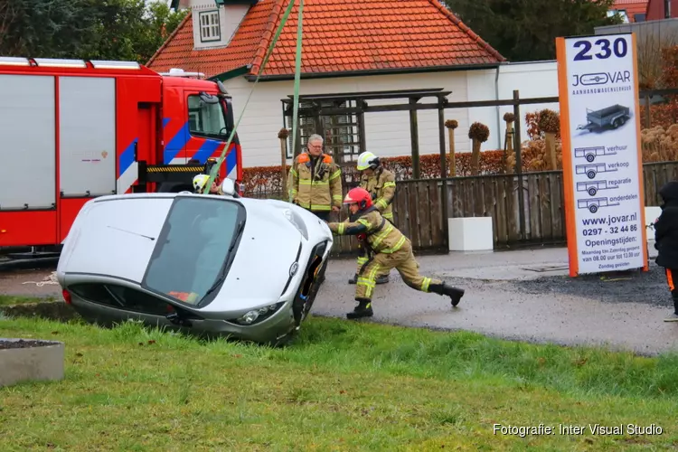 Auto op zijkant in greppel Aalsmeer