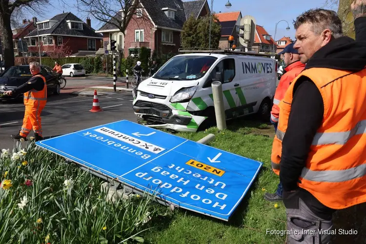 Bestelbus rijdt verkeerslicht uit de grond. Bestuurder naar ziekenhuis