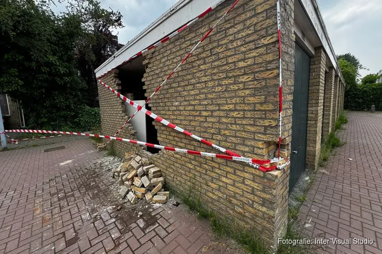 Vrachtwagen tegen gevel garageboxen gereden