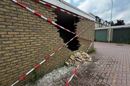 Vrachtwagen tegen gevel garageboxen gereden