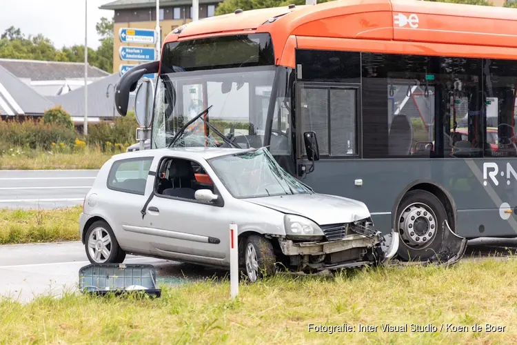 Auto op zijn kant na aanrijding met lijnbus