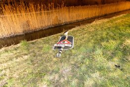 Auto rijdt waarschuwingslicht uit de grond