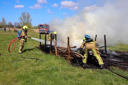 Graafmachine schiet brandweer te hulp bij brand in houtstapel voor insecten