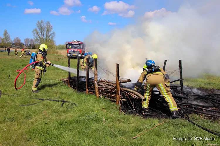 Graafmachine schiet brandweer te hulp bij brand in houtstapel voor insecten