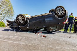 Auto botst op betonblok en vliegt over de kop