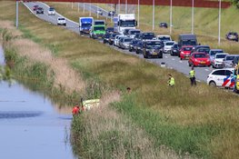 Personenauto belandt op zijn kop in het water, overlast voor verkeer