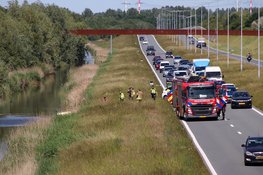 Personenauto belandt op zijn kop in het water, overlast voor verkeer
