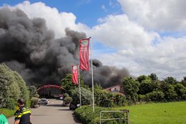 Grote brand bij bouwbedrijf. Zwarte rookwolken in wijde omgeving te zien, NL alert verzonden